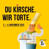 Koch steht hinter kleinem Törtchen in einer Glasvetrine. Daneben der Spruch: "Du Kirsche. Wir Torte." 