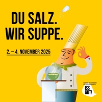 Koch steht vor Suppenschüssel in Glasvetrine. Daneben der Spruch: "Du Salz. Wir Suppe."